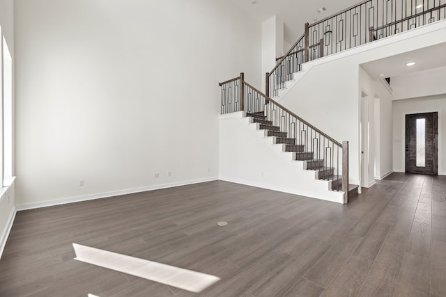 interior space with a high ceiling and dark wood-type flooring