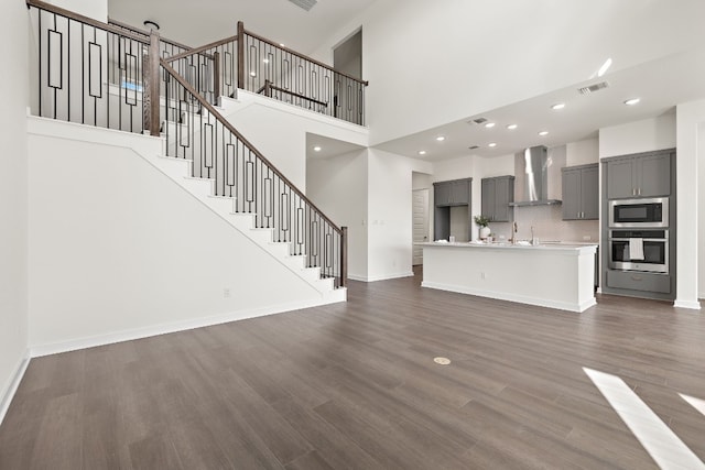 unfurnished living room with a high ceiling and dark hardwood / wood-style floors