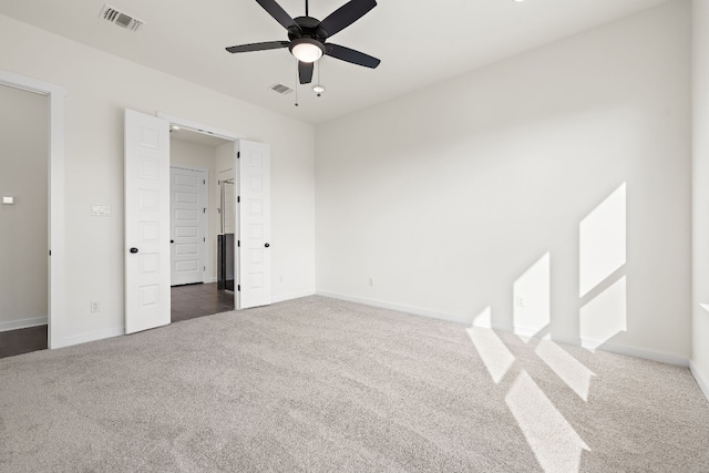 unfurnished bedroom with ceiling fan and dark carpet