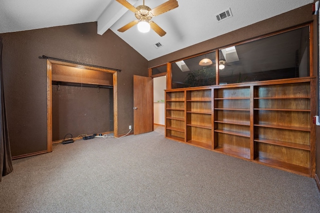 unfurnished bedroom with vaulted ceiling with beams, ceiling fan, a closet, and carpet floors