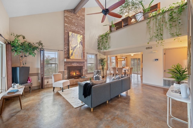 living room with beam ceiling, ceiling fan, a brick fireplace, high vaulted ceiling, and concrete flooring