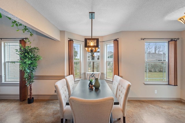 dining room with a textured ceiling, a wealth of natural light, and a notable chandelier