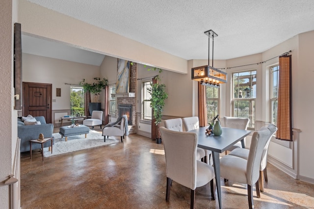 dining space featuring a fireplace, a chandelier, and a textured ceiling