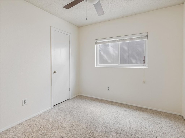 carpeted empty room with ceiling fan and a textured ceiling