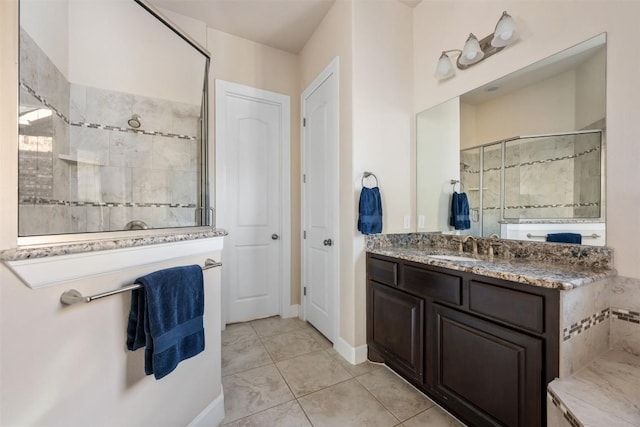 bathroom featuring tile patterned floors, vanity, and a shower with shower door