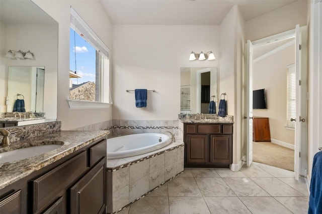 full bathroom featuring a sink, a garden tub, two vanities, and tile patterned flooring