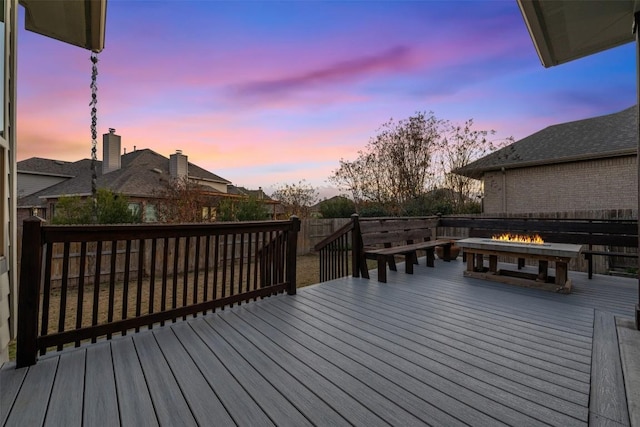 deck at dusk featuring fence and an outdoor fire pit