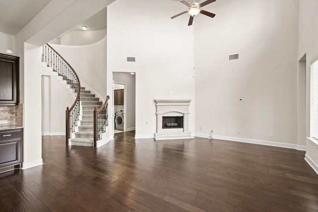 2715 Mariposa Way, Round Rock, TX 78665 - unfurnished living room featuring washer / clothes dryer, a high ceiling, ceiling fan, stairs, and dark wood-type flooring