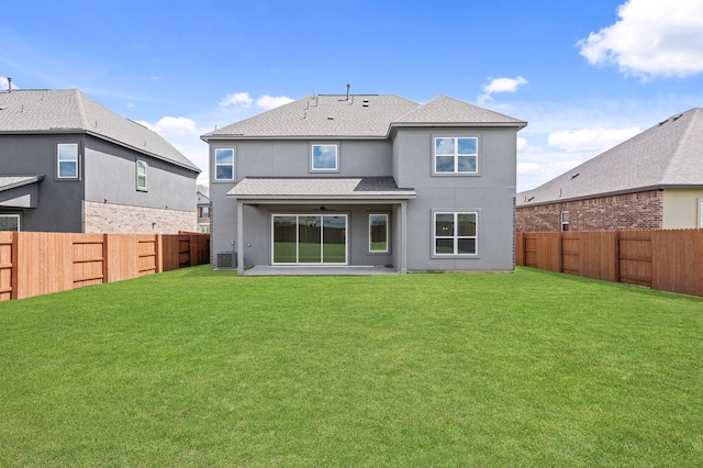 back of property with a yard and central AC unit