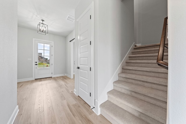 foyer with light hardwood / wood-style floors and an inviting chandelier