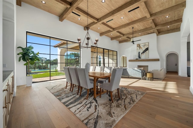 dining area with beam ceiling, a towering ceiling, and wood ceiling