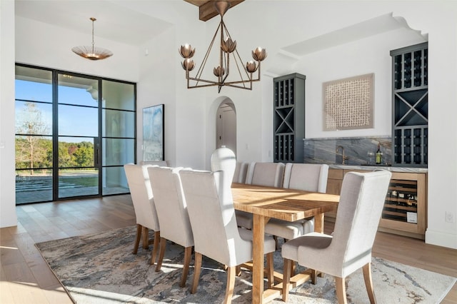 dining room with hardwood / wood-style floors, wet bar, and beverage cooler