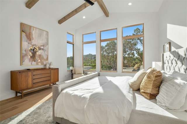 bedroom with vaulted ceiling with beams and light hardwood / wood-style floors