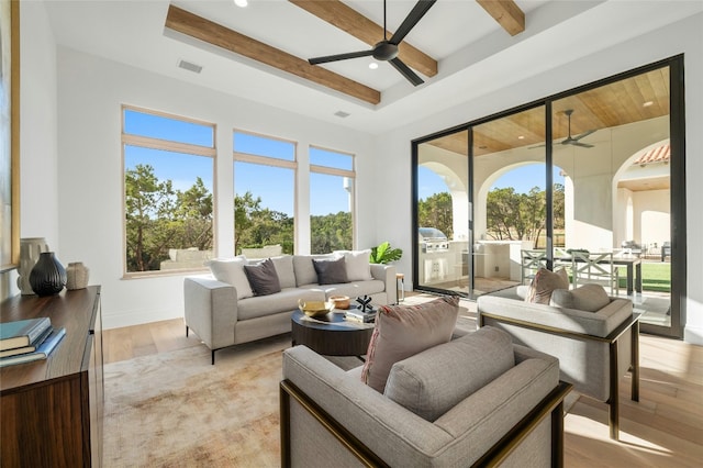 sunroom / solarium with beamed ceiling, ceiling fan, and a wealth of natural light