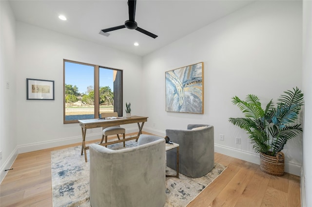 home office with light hardwood / wood-style floors and ceiling fan