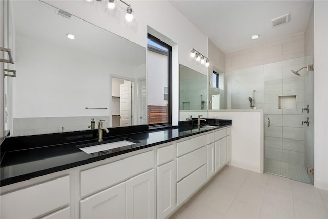 7501 Becasseau Dr, Austin, TX 78738 - bathroom with a shower stall, double vanity, tile patterned floors, and a walk in closet