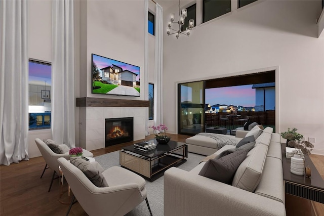 7501 Becasseau Dr, Austin, TX 78738 - living room with wood finished floors, a tiled fireplace, a chandelier, and a towering ceiling