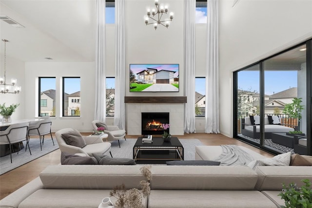7501 Becasseau Dr, Austin, TX 78738 - living room with a chandelier, healthy amount of natural light, a high ceiling, a fireplace, and wood finished floors