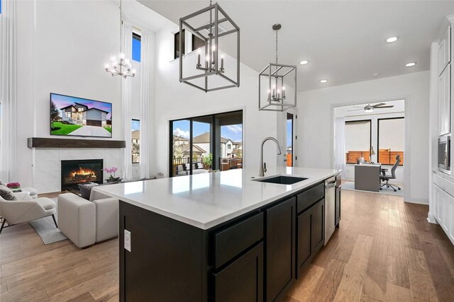 7501 Becasseau Dr, Austin, TX 78738 - kitchen featuring a chandelier, light wood-style flooring, a kitchen island with sink, light countertops, and recessed lighting