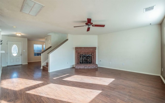 unfurnished living room featuring a fireplace, dark hardwood / wood-style flooring, and ceiling fan