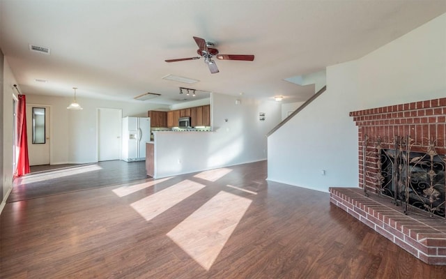 unfurnished living room with ceiling fan, dark hardwood / wood-style flooring, and a fireplace