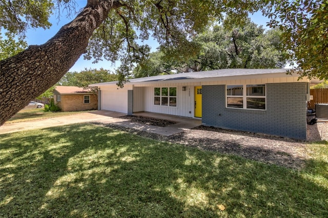 ranch-style house with cooling unit, a front lawn, and a garage