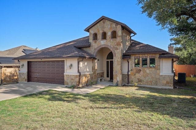 view of front of house featuring cooling unit, a front yard, and a garage