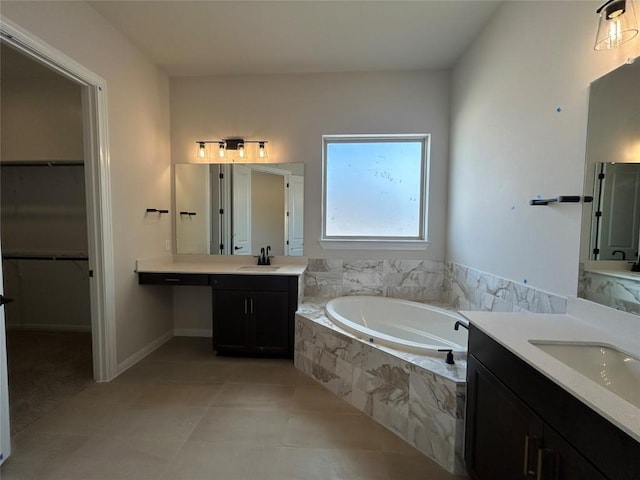 bathroom featuring a walk in closet, a garden tub, a sink, and tile patterned floors