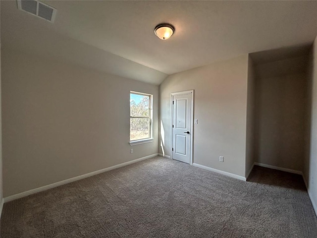 unfurnished bedroom with carpet, baseboards, visible vents, and vaulted ceiling