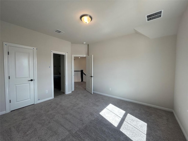 unfurnished bedroom featuring carpet, visible vents, and baseboards