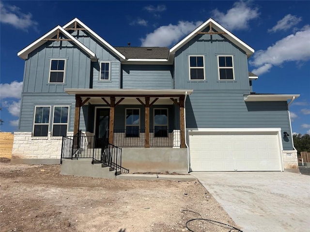 view of front facade with driveway, an attached garage, a porch, and board and batten siding