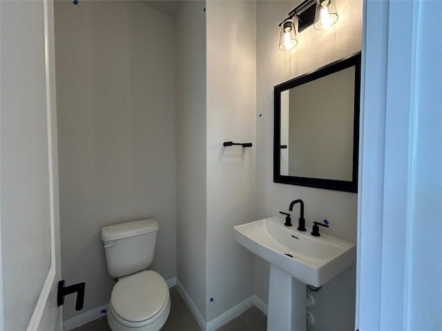 bathroom with toilet and baseboards