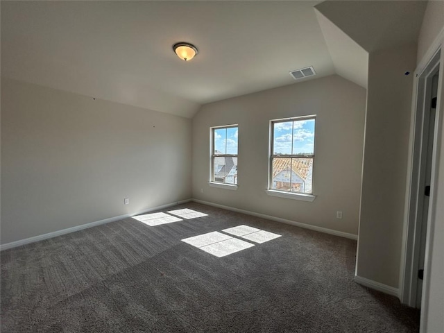 interior space featuring carpet floors, lofted ceiling, visible vents, and baseboards