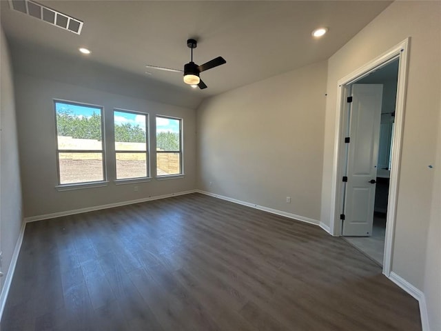 unfurnished room with dark wood-style floors, visible vents, baseboards, and recessed lighting