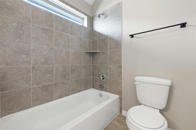 bathroom with tile patterned flooring, toilet, and tiled shower / bath