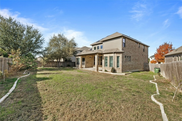 rear view of property with a yard and a patio