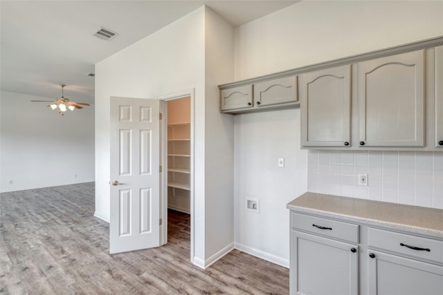 kitchen with tasteful backsplash, gray cabinets, ceiling fan, and lofted ceiling