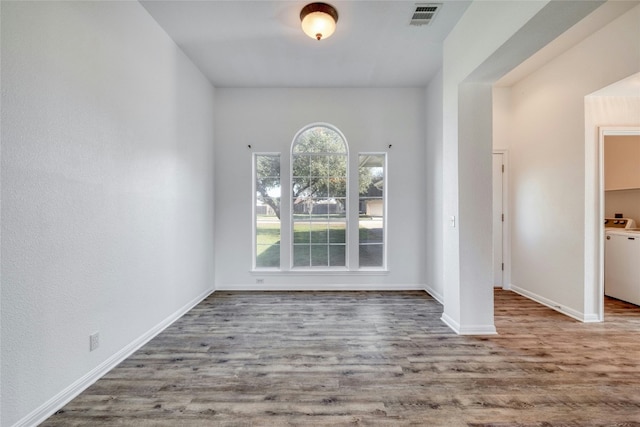 unfurnished room with hardwood / wood-style floors and washer / dryer