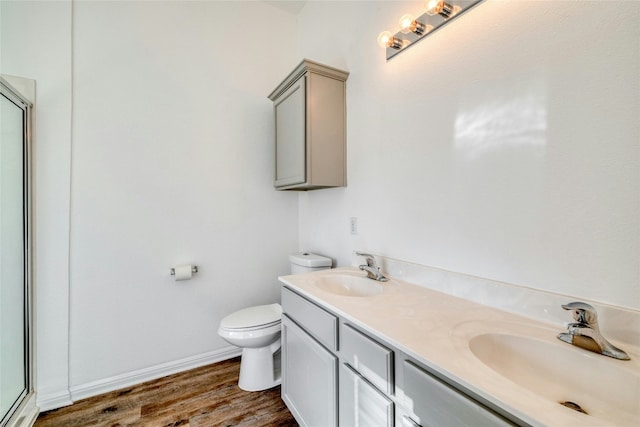 bathroom with an enclosed shower, vanity, toilet, and hardwood / wood-style flooring