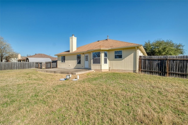 rear view of property featuring a yard and a patio