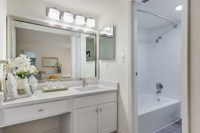 bathroom with hardwood / wood-style floors, vanity, and washtub / shower combination