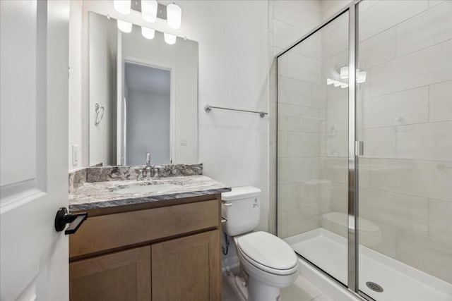 bathroom with vanity, toilet, and a shower with shower door