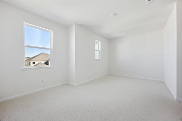 unfurnished room featuring light colored carpet and a healthy amount of sunlight