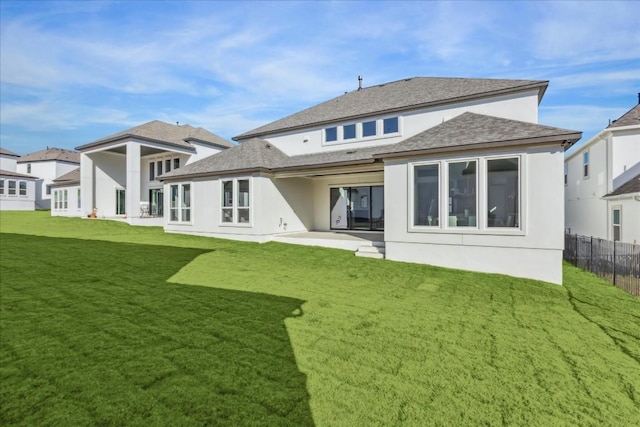 rear view of property featuring a lawn and a patio area