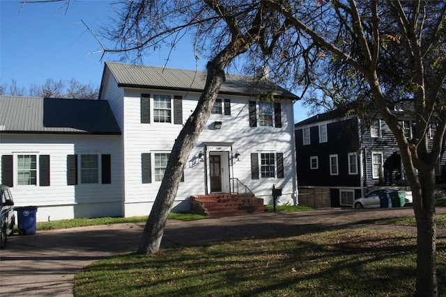 colonial house featuring a front lawn