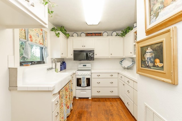 kitchen with dark hardwood / wood-style flooring, white range, tasteful backsplash, and white cabinetry