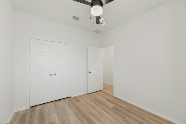 unfurnished bedroom featuring a closet, light hardwood / wood-style flooring, and ceiling fan