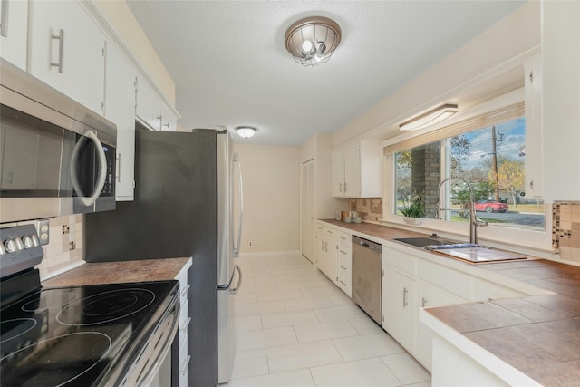 kitchen with white cabinets, appliances with stainless steel finishes, and tasteful backsplash