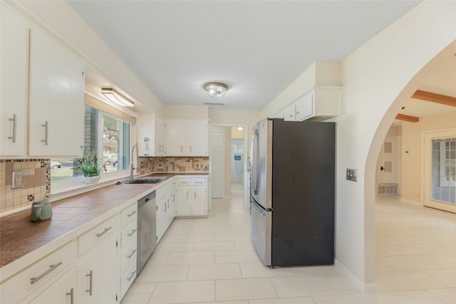 kitchen with white cabinets, appliances with stainless steel finishes, backsplash, and sink