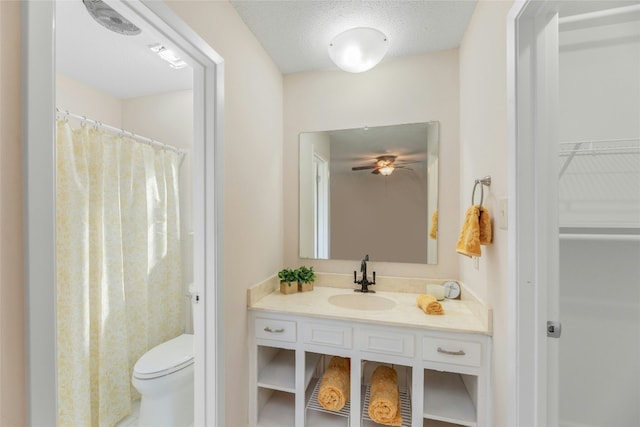 bathroom featuring a shower with curtain, vanity, toilet, and a textured ceiling